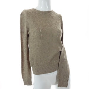 May include: A light brown, long-sleeved sweater with a loose, open knit pattern.