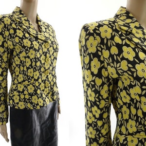 Puede incluir: Una chaqueta negra con estampado floral amarillo, cuello de solapa y cierre de botones.