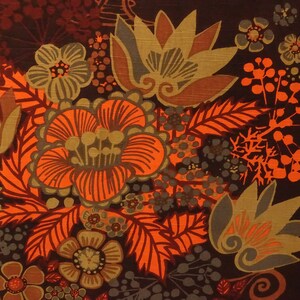 May include: A brown fabric with a floral pattern in shades of orange, brown, and green. The flowers are stylized and have a retro feel.