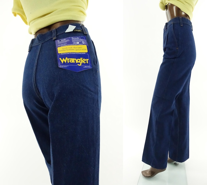 May include: A pair of dark blue denim jeans with a wide leg. The jeans have a label on the back pocket that says "Wrangler" and "Boot cut, flares, standard fit, jean style".