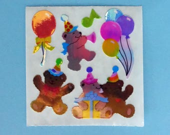 May include: A sheet of colorful stickers featuring four teddy bears wearing party hats and holding balloons. The bears are surrounded by balloons in shades of pink, blue, yellow, and red.