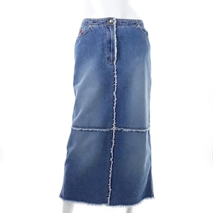 Peut inclure: Une longue jupe en jean avec un ourlet effiloché et un design patchwork. La jupe est d'un bleu moyen et a une silhouette droite.
