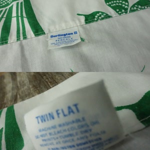 May include: White twin flat sheet with a green floral pattern. The sheet is made of a no-iron percale fabric blend of 50% cotton and 50% polyester.
