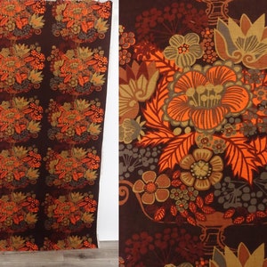 May include: A brown fabric with a repeating pattern of orange, brown, and gray stylized flowers. The fabric has a vintage feel.