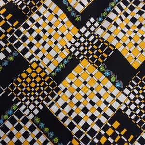 May include: Black fabric with a checkered pattern in white, yellow, and black. The fabric has a repeating pattern of small blue and green flowers.