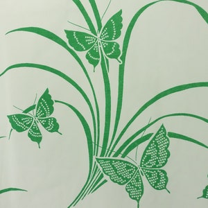 May include: A white background with a green pattern of butterflies and grass.