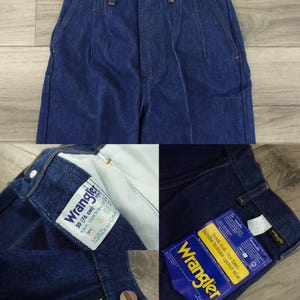 May include: A pair of blue denim Wrangler jeans with a boot cut leg. The jeans have a zipper fly and a button closure. The size tag says "30 (76 cm)" and "100% Cotton".