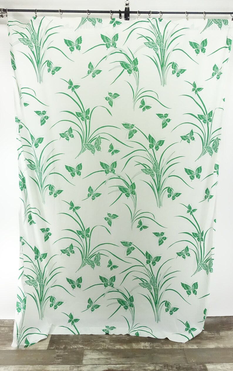 May include: White fabric with a green butterfly and grass pattern.