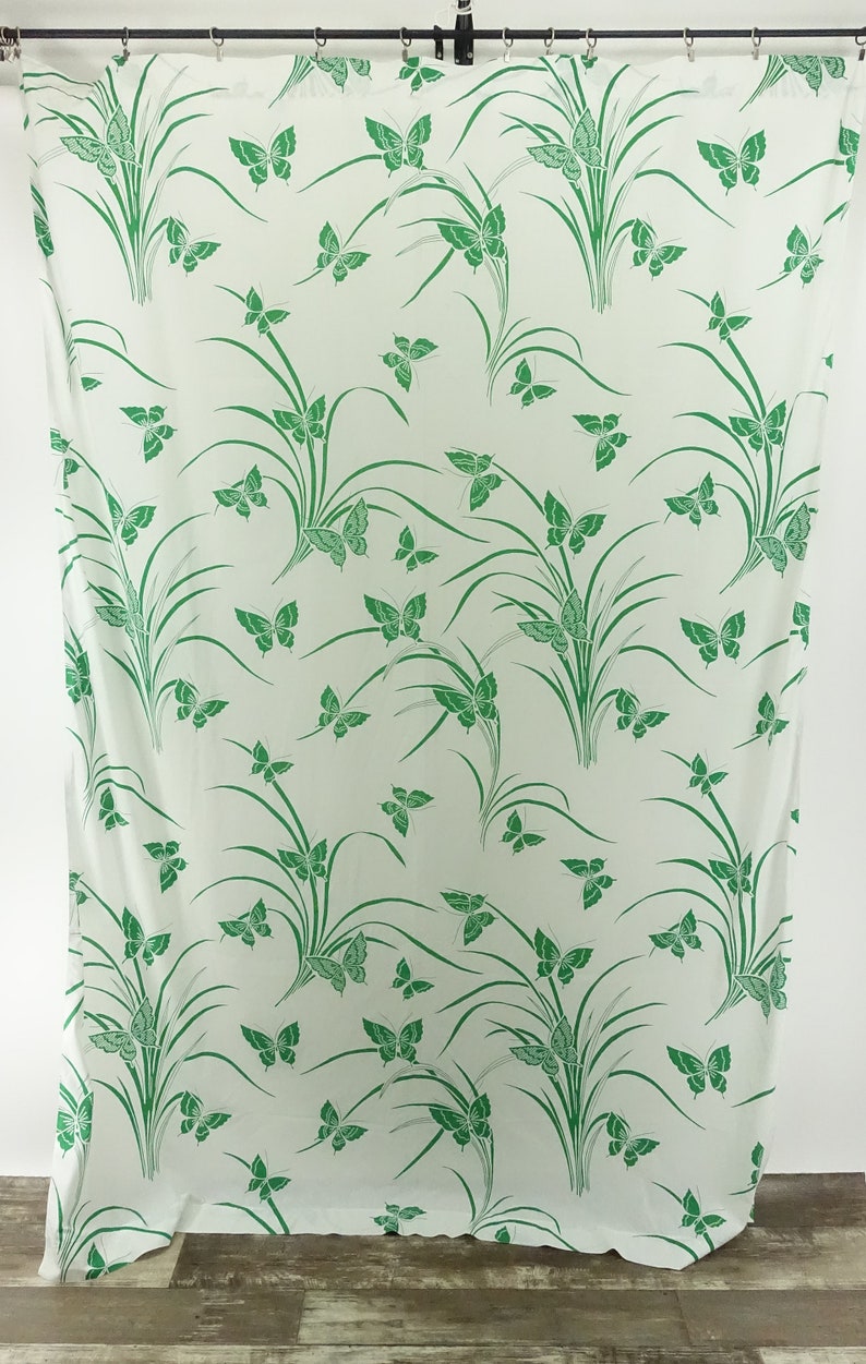 May include: White fabric with a green butterfly and grass pattern.