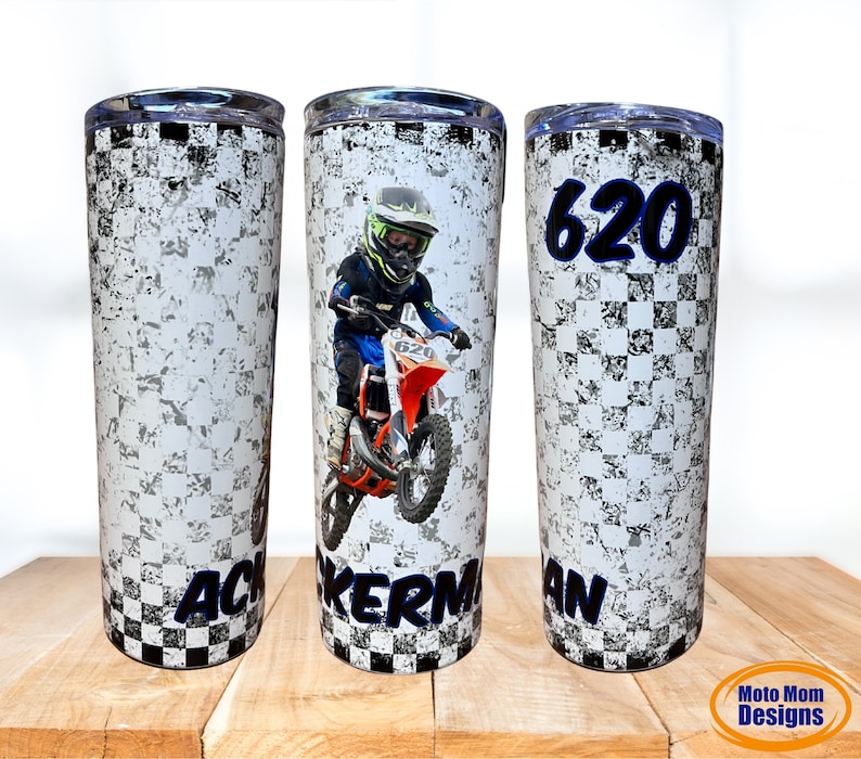 May include: Three stainless steel tumblers with a checkered pattern and a dirt bike design. The center tumbler features a photo of a child riding a dirt bike. The left tumbler has the text "ACKERMAN" and the right tumbler has the text "620 AN".