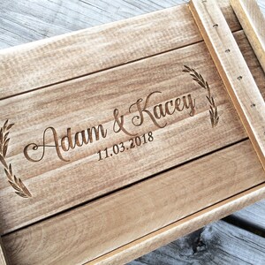 May include: A wooden box with a personalized inscription that reads "Adam & Kacey 11.03.2018". The inscription is surrounded by a decorative leaf design.