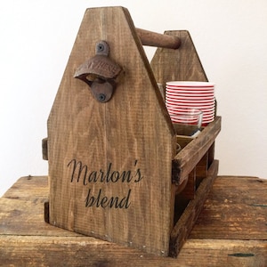 May include: Wooden six-pack carrier with a handle, bottle opener, and a personalized inscription that reads "Marlon's Blend".