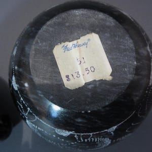 Pu&ograve; includere: Una ciotola rotonda in pietra grigio scuro con coperchio, con venature bianche e un'etichetta di carta. L'etichetta recita "Fred Harvey" e include un numero. La superficie della ciotola &egrave; lucida e riflette la luce.