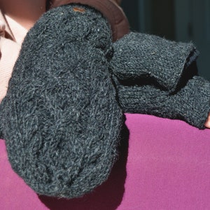 May include: Dark gray knitted mittens and fingerless gloves. The mittens are thick and textured, while the fingerless gloves have a ribbed cuff. The items are made of a soft, warm material, perfect for cold weather.