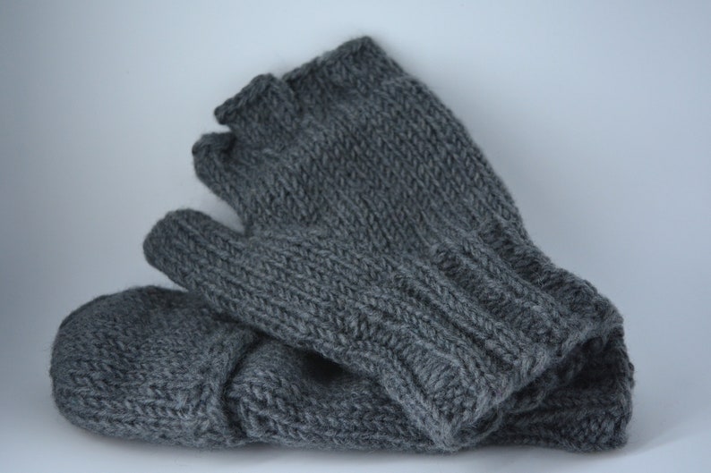 May include: A pair of gray knitted fingerless gloves. The gloves are made of a soft, textured yarn and feature a ribbed cuff and a simple knit stitch pattern. The gloves are designed to keep hands warm while leaving fingers free.