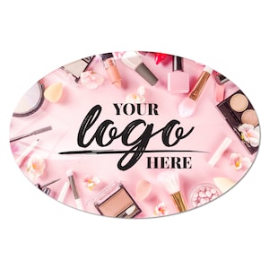May include: Pink oval sticker with a variety of makeup products, including brushes, lipstick, nail polish, and eyeshadow palettes. The text "YOUR logo HERE" is in the center of the sticker.