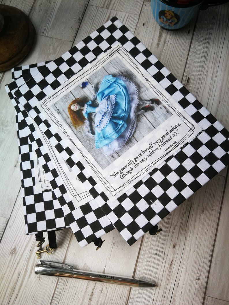 May include: Three black and white checkered notebooks with a quote from Lewis Carroll's Alice in Wonderland. The quote reads "She generally gave herself very good advice, (though she very seldom followed it)."  The notebooks feature a photo of a doll dressed as Alice falling down a rabbit hole.