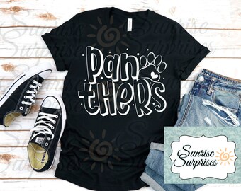 May include: Black t-shirt with white text that says "Panthers" with a paw print and heart. The shirt is laying on a wooden surface with a pair of black sneakers and blue jeans.