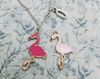 May include: A silver chain necklace with two flamingo charms. One flamingo is pink and the other is light pink.