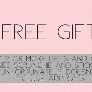 以下が含まれることがあります： ピンクの背景に黒い文字で「FREE GIFT」と書いてあります。テキストの下には、灰色の長方形があり、「BUY 2 OR MORE ITEMS AND GET A FREE SCRUNCHIE AND STICKERS UNFORTUNATELY DOESN'T INCLUDE ADD ON'S」と書いてあります。