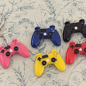 以下が含まれることがあります： カラフルなプラスチック製のゲームコントローラーキーホルダー6個。キーホルダーはピンク、ブルー、ブラック、レッド、イエロー。各キーホルダーにはシルバーリングが付いています。