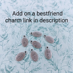 May include: Seven silver oval charms with the text "Best Friends" on each charm.