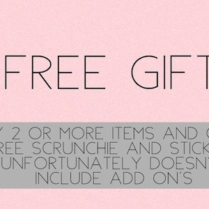 May include: Pink background with the text "FREE GIFT" in black. Below the text is a gray bar with the text "BUY 2 OR MORE ITEMS AND GET A FREE SCRUNCHIE AND STICKERS UNFORTUNATELY DOESN'T INCLUDE ADD ON'S".