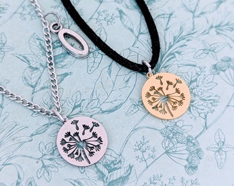 Puede incluir: Dos collares con dijes de diente de león. Un collar tiene un dije de plata y una cadena de plata. El otro collar tiene un dije de oro y un cordón negro.