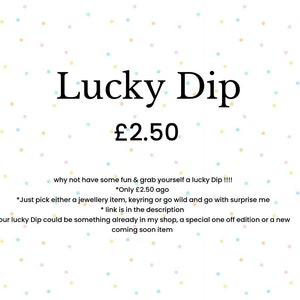 May include: White background with pastel polka dots. The text "Lucky Dip" is displayed in a large, elegant font. Below, the price is listed. Additional text describes the item as a surprise selection of jewelry, keyrings, or other items.