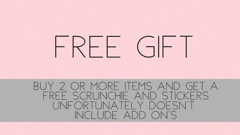 May include: Pink background with the text "FREE GIFT" in black. Below the text is a grey bar with the text "BUY 2 OR MORE ITEMS AND GET A FREE SCRUNCHIE AND STICKERS UNFORTUNATELY DOESN'T INCLUDE ADD ON'S".