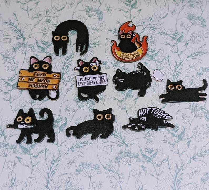 May include: A collection of black cat-shaped stickers with various designs and text. Some cats have signs that read "FEED ME MEOW HOOMAN" and "IT'S FINE, I'M FINE EVERYTHING IS FINE". Other stickers feature cats in flames and the words "NOT TODAY".
