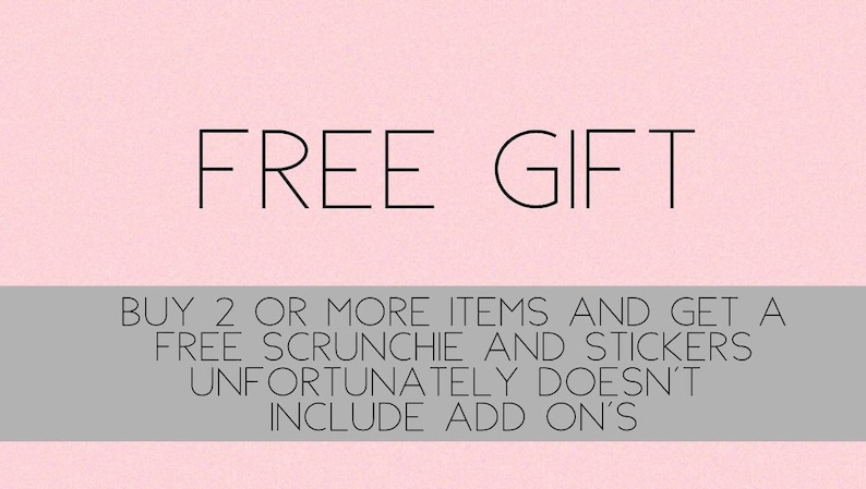 Może przedstawiać: R&oacute;żowe tło z tekstem "FREE GIFT" w kolorze czarnym. Pod tekstem znajduje się szary pasek z tekstem "BUY 2 OR MORE ITEMS AND GET A FREE SCRUNCHIE AND STICKERS UNFORTUNATELY DOESN'T INCLUDE ADD ON'S".