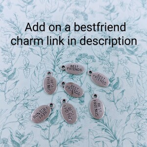 May include: Seven silver oval charms with the text "Best Friends" on each charm.