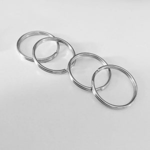 May include: Four silver key rings of different sizes, linked together.