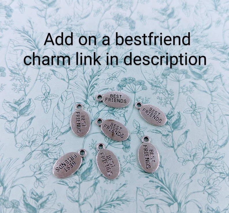 Pu&ograve; includere: Sette ciondoli ovali in argento con la scritta "Best Friends" su ogni ciondolo.