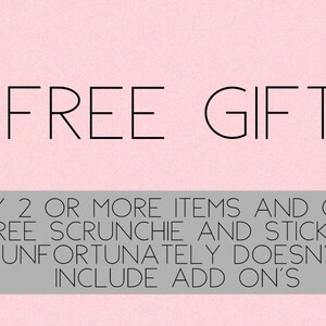 May include: Pink background with the text "FREE GIFT" in black. Below the text is a gray bar with the text "BUY 2 OR MORE ITEMS AND GET A FREE SCRUNCHIE AND STICKERS UNFORTUNATELY DOESN'T INCLUDE ADD ON'S".