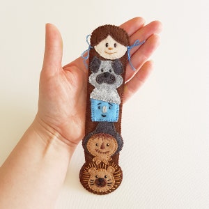 May include: A felt finger puppet set featuring characters from the Wizard of Oz. The set includes Dorothy, Toto, the Scarecrow, the Tin Man, and the Cowardly Lion. Each puppet is made of felt and has embroidered details.