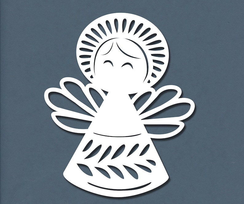 May include: White paper cut-out of an angel with a halo, wings, and a simple dress. The angel has a smiling face.