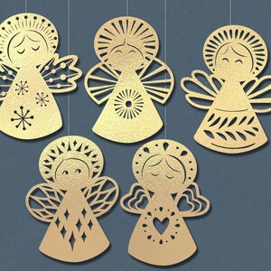 May include: Five gold paper angel ornaments with intricate cut-out designs. Each angel has a different pattern and features a halo, wings, and a simple face.