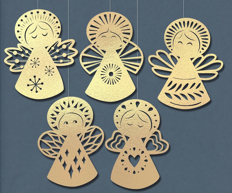 May include: Five gold paper angel ornaments with intricate cut-out designs. Each angel has a different pattern and features a halo, wings, and a simple face.