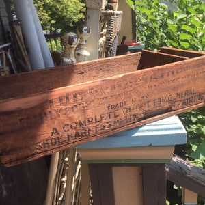 May include: A wooden crate with black lettering that reads "A Complete Light F34 General Saddle Harness and Trim". The crate is weathered and has a rustic appearance.