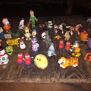 May include: A collection of vintage wind-up toys, including a snowman, a chick, a tiger, a monkey, a dolphin, a pair of red shoes, a turtle, a rabbit, a horse, a penguin, a duck, a bear, a monster, a robot, a rooster, a girl doll, a snowman, and a dog.