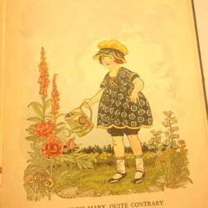 May include: A young girl in a blue and white floral dress and yellow hat waters a garden with a green watering can. The garden has pink flowers, purple flowers, and green leaves. The text "Mistress Mary, Quite Contrary" is printed below the image.