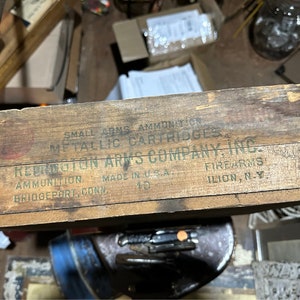 May include: A wooden box with the text "SMALL ARMS AMMUNITION METALLIC CARTRIDGES REDINGTON ARMS COMPANY, INC. AMMUNITION MADE IN U.S.A. BRIDGEPORT, CONN. 10 FIREARMS ILION, N.Y." printed on the top.