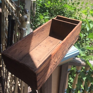 May include: A wooden box with two compartments, the box is weathered and has a label that reads "A.C. MILLER & CO. ST. LOUIS, MO."