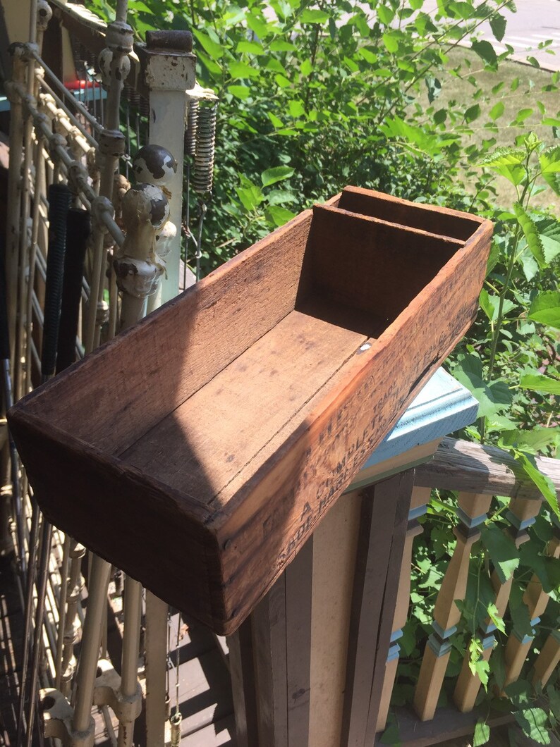 May include: A wooden box with two compartments, the box is weathered and has a label that reads "A.C. MILLER & CO. ST. LOUIS, MO."