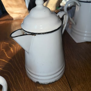 May include: A set of three ceramic mugs with a speckled, matte finish. The mugs are in shades of cream, light brown, and dark brown. Each mug has a simple, minimalist design, perfect for coffee or tea.