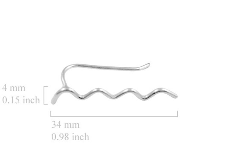 May include: A silver-colored ear cuff with a wavy design. The ear cuff is 0.98 inches long and 0.15 inches wide. The design features a series of curved lines, creating a wave-like pattern. The ear cuff curves over the ear.