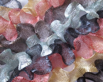 May include: An abstract composition of woven wire forms in various colors. The forms are in shades of red, black, silver, gold, and blue. The shapes are organic and flowing, creating a textured, three-dimensional effect.