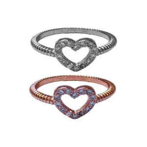 May include: Two heart-shaped rings with a pave setting of clear stones. The ring on top is silver, and the ring on the bottom is rose gold.